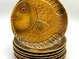 une assiette en or ornée d'un motif de poisson