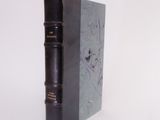 a black book that is sitting on a white surface