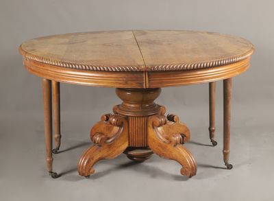 une table à manger ovale avec deux rallonges sur le plateau et deux rallonges sur le piètement