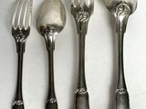 four forks and spoons are lined up on a white surface