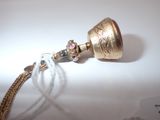 a gold bell with a chain attached to it