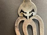 a silver spoon with an octopus on it on a table