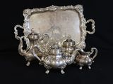 an antique silver tea set with a tray and a mirror