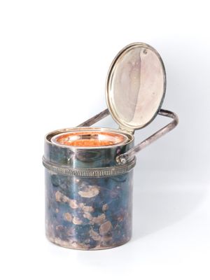 a small metal container with a lid on a white surface