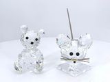 crystal figurines of a mouse and a cat on a white surface