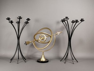 trois bougeoirs en métal noir et doré, ornés d'un motif en spirale doré