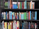une bibliothèque noire sur laquelle sont posés de nombreux livres