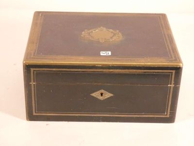 une petite boîte noire ornée d'un motif doré