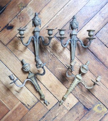three antique cast iron candelabs on a wooden floor