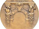an image of a gold medal with two statues on it