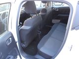 a white car with its door open and a black seat in the back