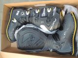 deux paires de chaussures de ski dans une boîte posée par terre