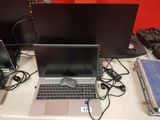 a laptop computer sitting on top of a desk next to two monitors