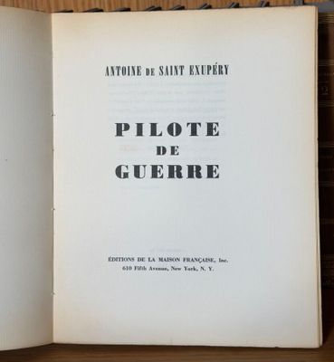 un livre ouvert posé sur une table en bois, avec une photo en noir et blanc
