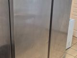 a stainless steel refrigerator in a kitchen with tile flooring
