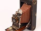 an old camera that is sitting on a piece of luggage