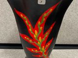 un vase noir orné d'un motif rouge et vert