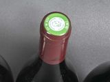 three bottles of red wine are lined up on a table
