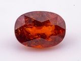 an oval shaped orange sapphire stone on a white surface