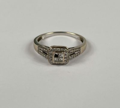 gros plan d'une bague en diamant sur une surface blanche