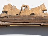 a wooden sculpture on top of a shelf on the wall
