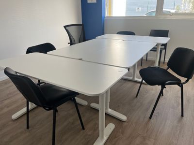 a white table with black chairs and a white table with a black chair