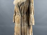 a fur coat on a mannequin stand against a gray background