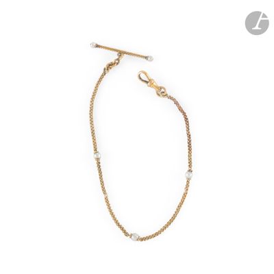 a close up of a gold chain bracelet with pearls on a white background