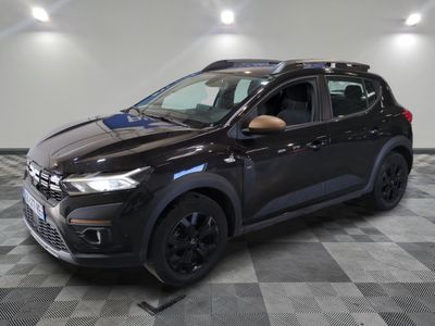 a black car is parked in a room with a checkered floor