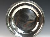 une photo d'une assiette en argent posée sur une table blanche