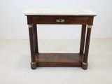 an old wooden table with a marble top on a white floor
