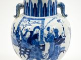 un vase bleu et blanc orné d'une anse en forme de dragon
