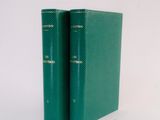 two green books sitting on top of each other on a white surface