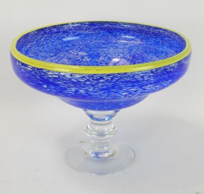 un bol en verre bleu à bord jaune posé sur une table