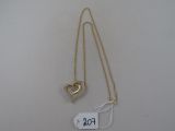 un gros plan sur un collier en or orné d'un cœur