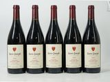 six bottles of wine are lined up in a row on a white surface