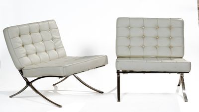 pair of white leather chairs with chrome legs against a white backdrop