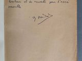 un livre ouvert, sur lequel est posée une note manuscrite, posé sur une table