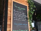 a chalk board on the wall of a restaurant that has a menu written on it