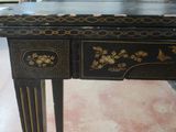 a black and gold table with a drawer on it