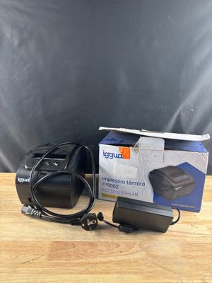une boîte contenant un appareil photo et un chargeur, posée sur une table