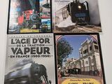 three books on a table with a train in the background