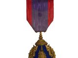 médaille violette et bleue avec un ruban rouge sur fond blanc