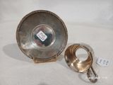 une assiette en argent antique avec une poignée sur une surface blanche