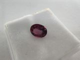 a close up of a pink sapphire stone on a white cloth