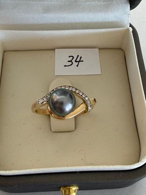 a ring with a pearl and diamonds in a box