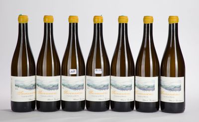 six bottles of wine are lined up in a row on a white surface