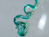 a glass vase with a green handle on a table