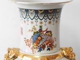a white vase with a gold trim and a floral design on it