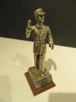 une statue en bronze représentant un homme coiffé d'un haut-de-forme et vêtu d'un uniforme